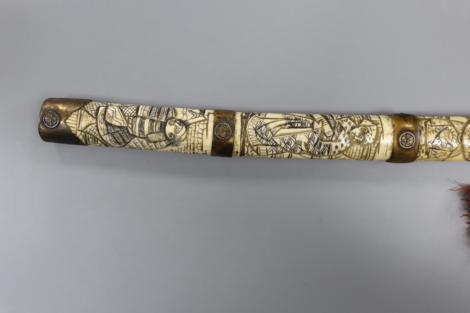 A late 19th century Japanese wakizashi sword, the blade 47.5cm, with sectional stag's horn scabbard and hilt carved with warriors and other figures, gilt metal mounted